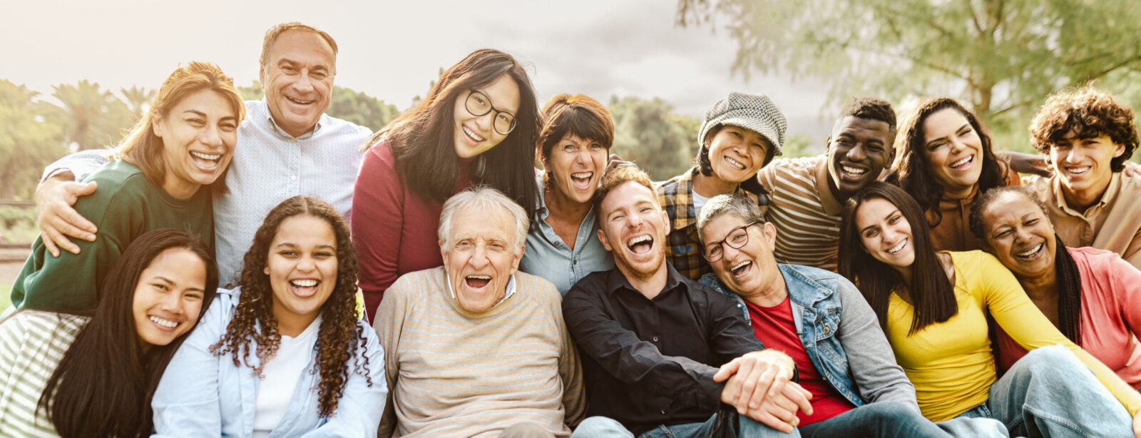 Happy multigenerational people having fun sitting on grass in a